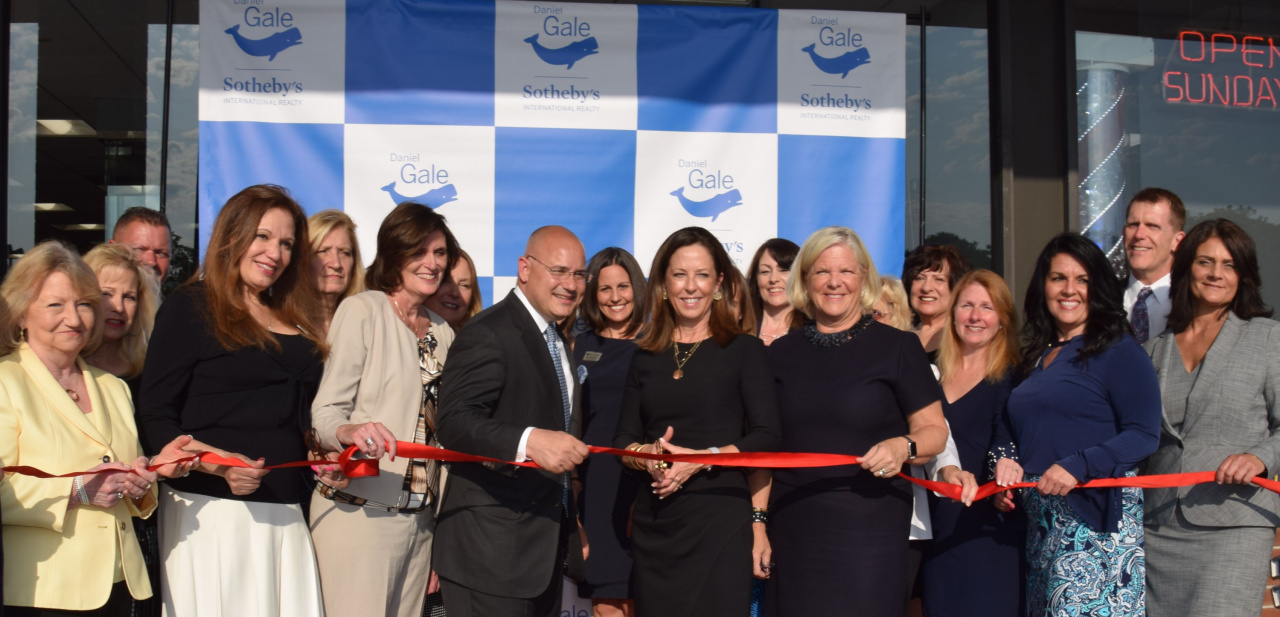 Pictured: Daniel Gale Sotheby’s International Realty CEO Deirdre O’Connell and Sales Manager Anthony DeGrotta (center) cut the ribbon on the organization’s new Smithtown office. They are joined by Smithtown Assistant Sales Manager Marianne Koke (on DeGrotta’s right) and Regional Manager Deborah Hauser (on O’Connell’s left) and surrounded by Daniel Gale Sotheby’s International Realty managers, sales agents, clients and friends.