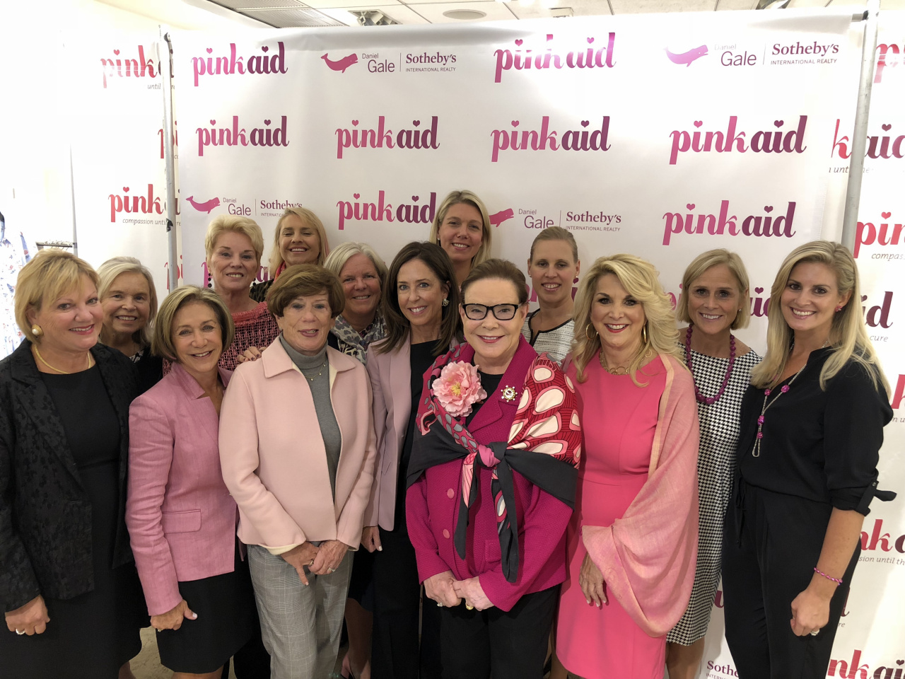 Pictured: Daniel Gale Sotheby’s International Realty was the title sponsor, and President and Chairman Pat Petersen the Luncheon Chair, of the 5th Annual Pink Aid Luncheon and Fashion Show, hosted at Mitchell’s clothing store in Huntington, NY. The event raised more than $500,000 to help underserved local women attain breast cancer diagnostics and treatment with support and dignity. Pictured here with Pat Petersen (front row center with scarf) are her colleagues and fellow supporters (l-r) Susan Poli, Bonnie Williamson, Lee Cunningham, Chief Executive Officer Deirdre O’Connell, Nikki Sturges, Tina McGowan and Quinn Bencivenga. Back row (l-r) Bonnie Devendorf, Diane Anderson, Ellen Hanes, Deborah Hauser, Katherine Cirelli and Marion Weiler.