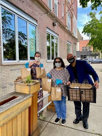 Left to right: Rachel Kane, Anne Rodia and David Bracy of Berkshire Hathaway HomeServices Chicago prepare to deliver Taco Tuesday meals as a thank you to frontline medical staff at Mercy Hospital.