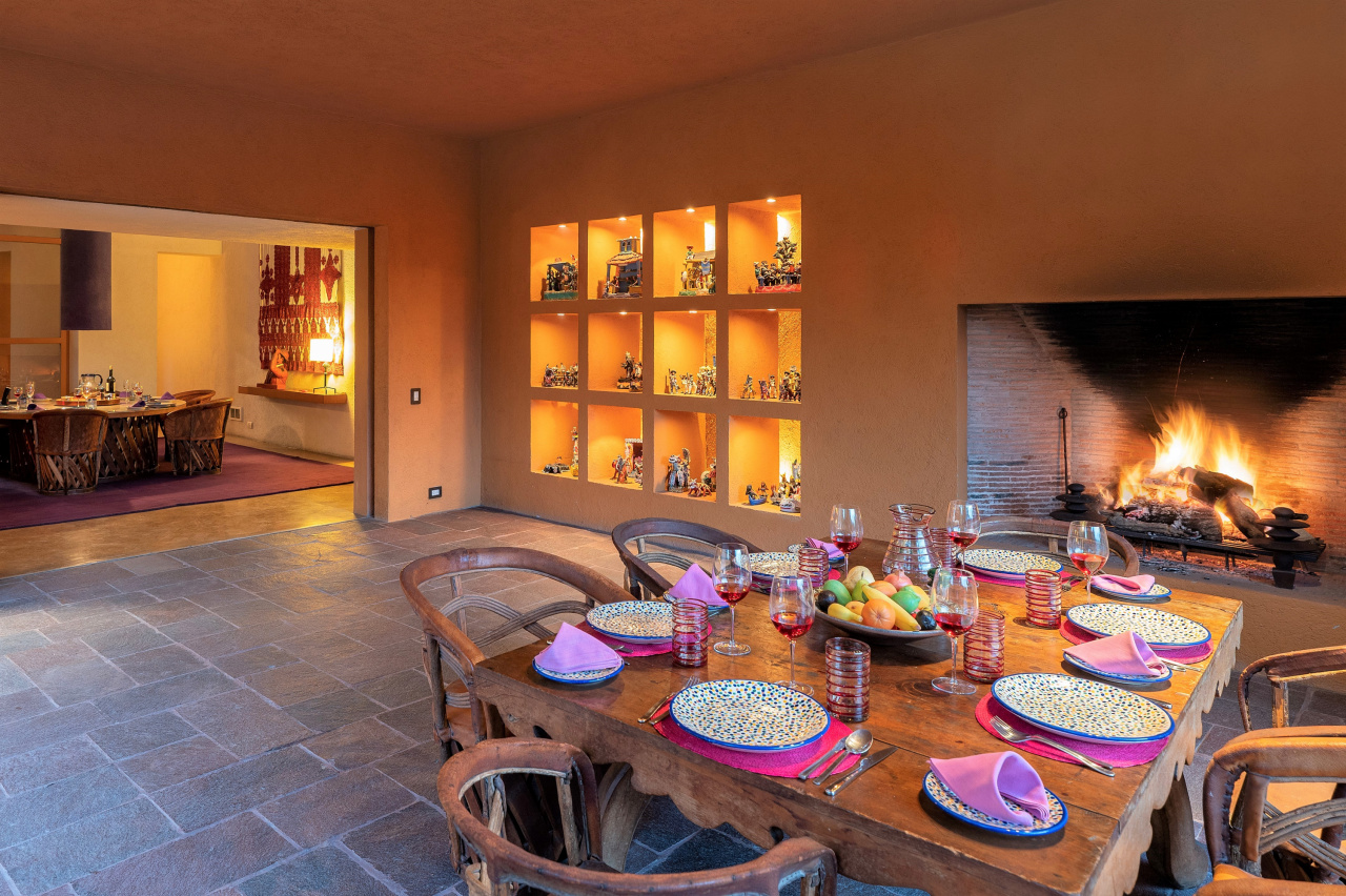 Dual dining rooms adjoin—indoor and outdoor—each with a wood-burning fireplace, adorned with plates bearing a Legorreta design.
